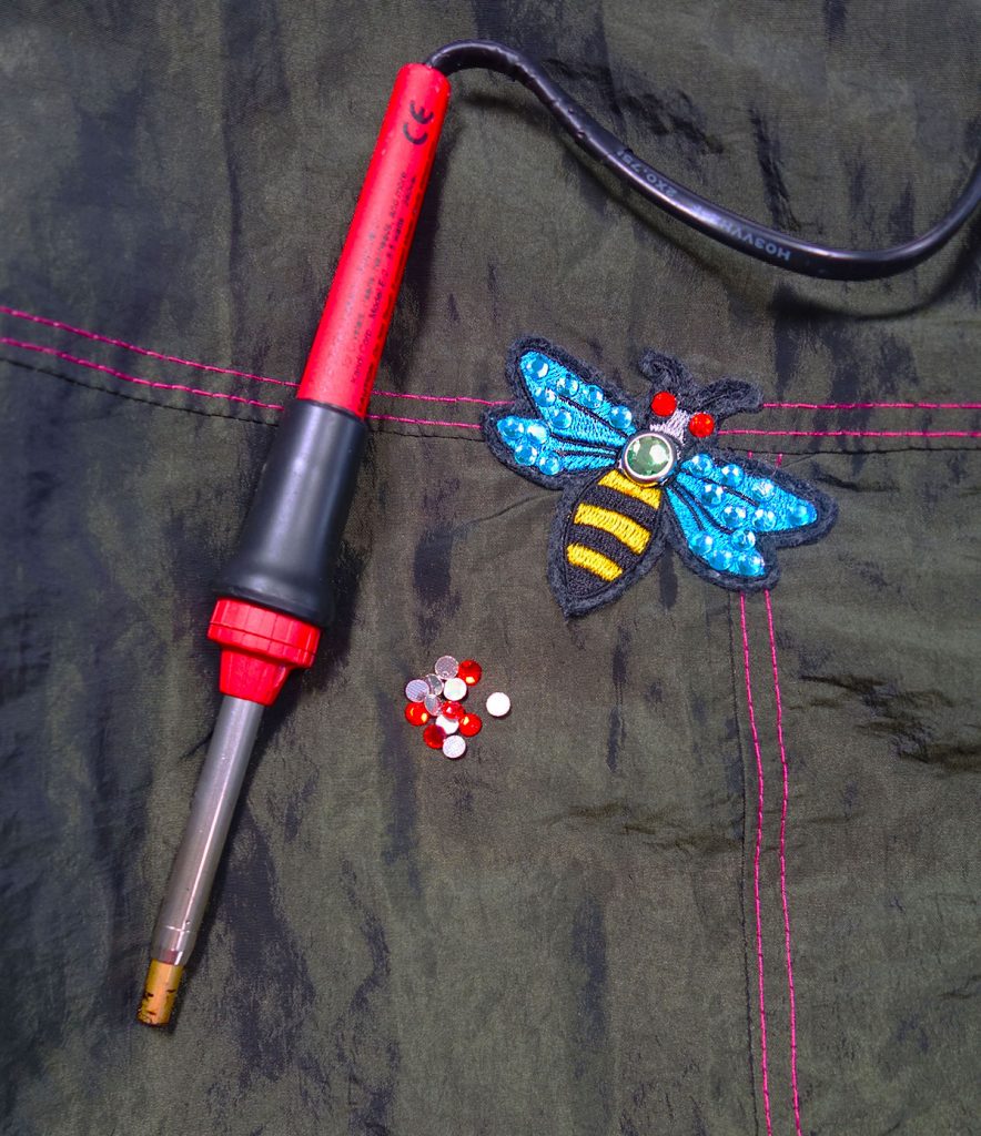 Strassteine mit einem Applikation aufkleben.